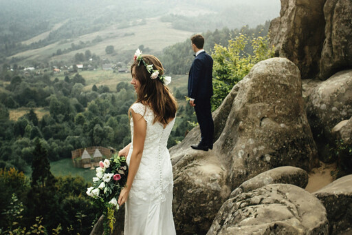 Hochzeitspaar auf Felsen stehend